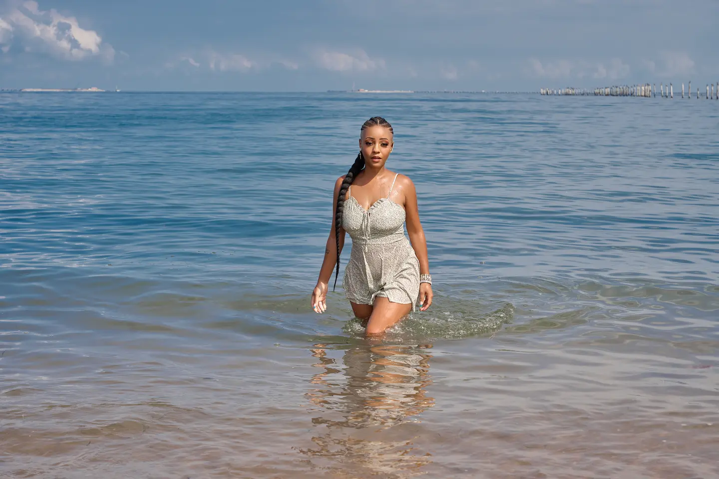 Jasmine Alysha walking through the shoreline in a silver fashion look