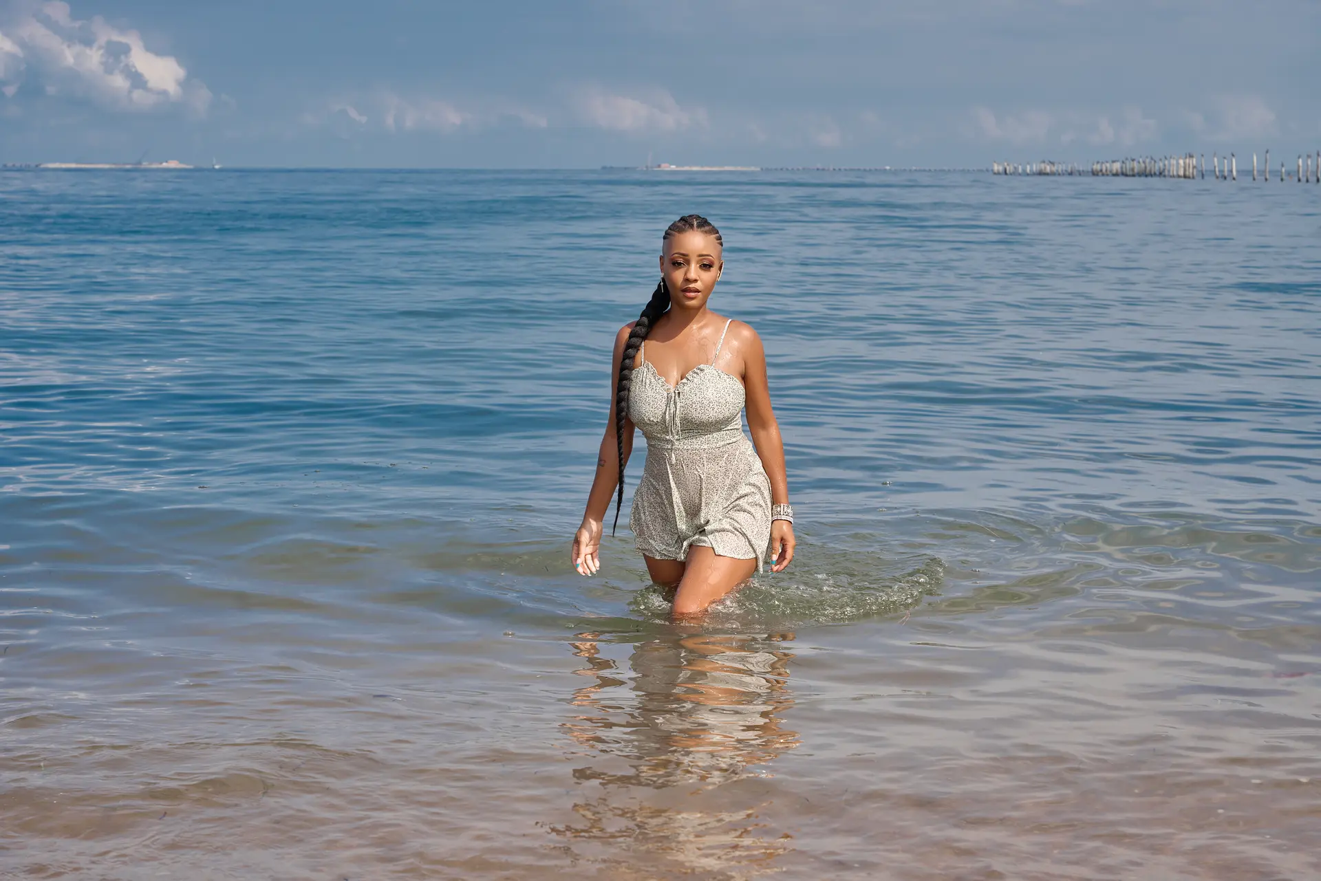Jasmine Alysha walking through the water in a silver look