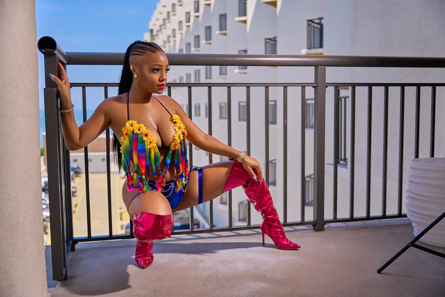 Jasmine Alysha seated in a colorful carnival-inspired fashion look